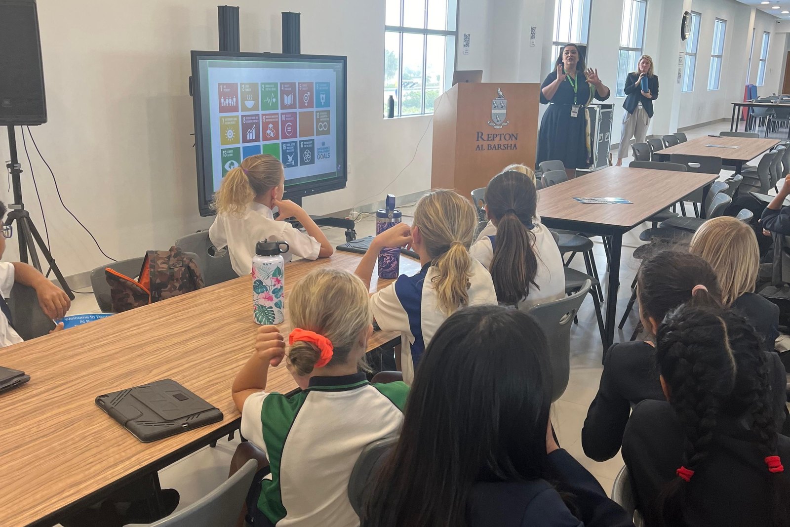 Nahla ElBanhawy presenting the United Nations Sustainable Development Goals on a large screen to a room of seated students